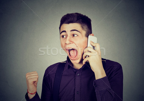 angry young man screaming on mobile phone Stock photo © ichiosea