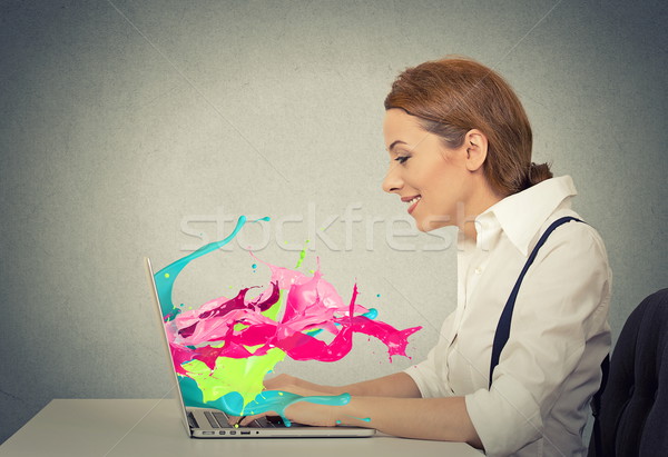 Woman working on computer colorful splashes coming out of screen Stock photo © ichiosea