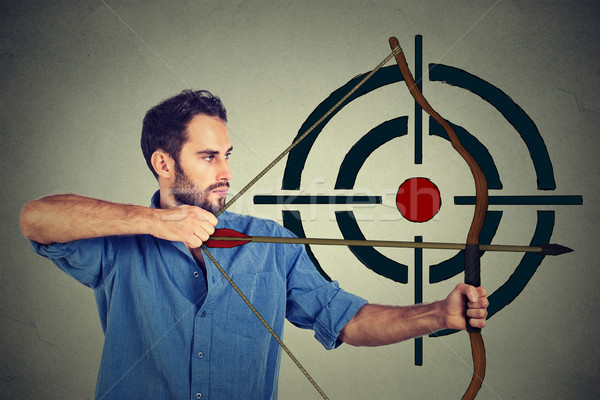 Side profile man trying to hit a target with bow and arrow Stock photo © ichiosea