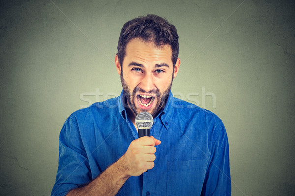 Closeup portrait frustrated man with microphone isolated on gray wall background  Stock photo © ichiosea