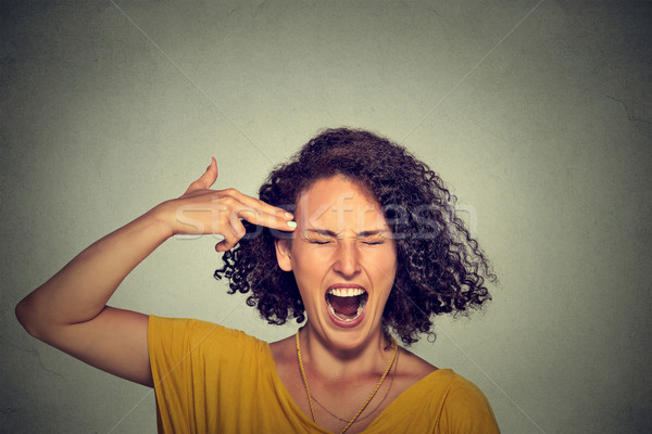 Stressed woman committing suicide with finger gun gesture  Stock photo © ichiosea