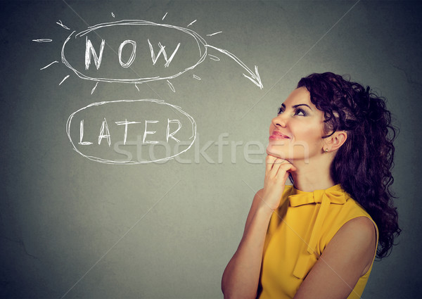 Stock photo: Now or later. Woman thinking looking up 