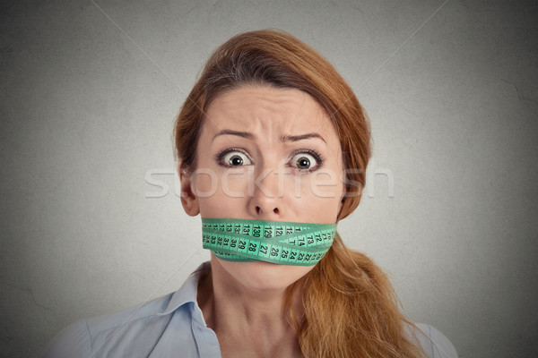 unhappy young woman with measuring tape covering mouth Stock photo © ichiosea