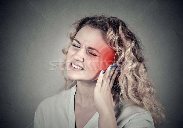 Stock photo: Tinnitus. Sick female having ear pain touching her painful head 