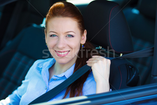 Woman pulling on seatbelt inside black car. Driving safety Stock photo © ichiosea
