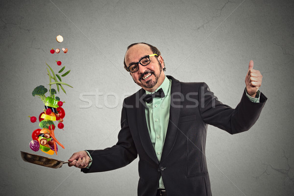 Businessman cooking vegetables with a pan  Stock photo © ichiosea