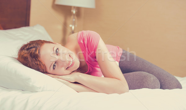 Cheerful woman lying on the bed at home daydreaming resting. Wellbeing and beauty concept  Stock photo © ichiosea