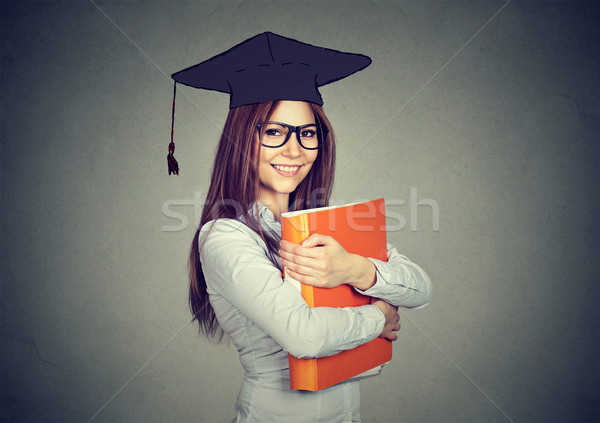 Graduate student woman in cap gown with folder looking at camera Stock photo © ichiosea