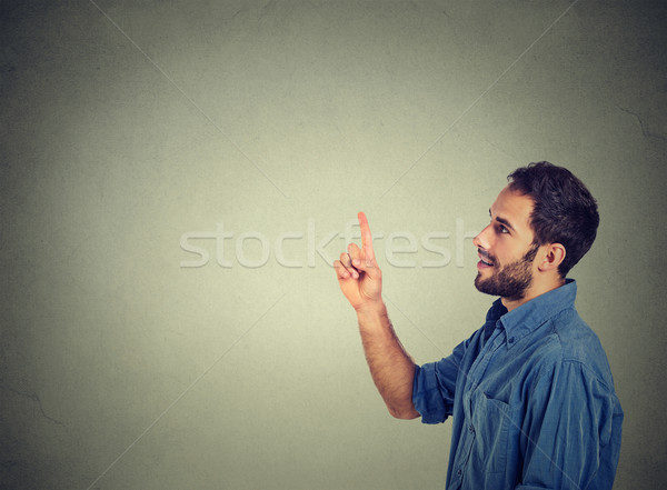 Happy young man pointing looking at copy space Stock photo © ichiosea