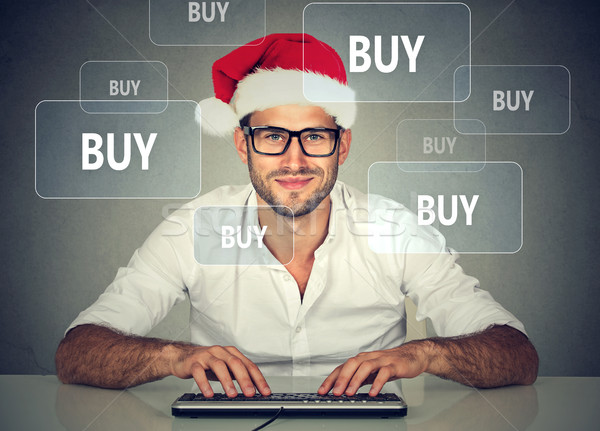 Happy christmas man in red santa claus hat buying stuff online Stock photo © ichiosea