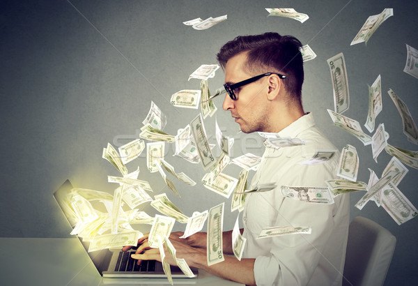 Side profile young man using a laptop computer making money  Stock photo © ichiosea