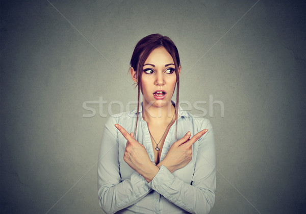 Confused woman pointing in two different directions not sure which way to go Stock photo © ichiosea