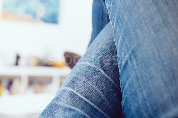 Nő lábak keresztbe visel farmernadrág megnyugtató edző Stock fotó © ifeelstock