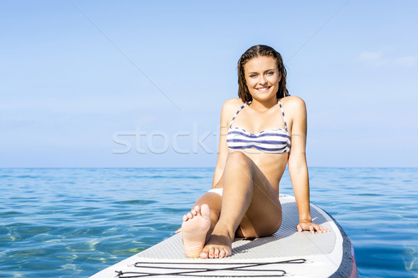 Woman sitting over a paddle surfboard Stock photo © iko