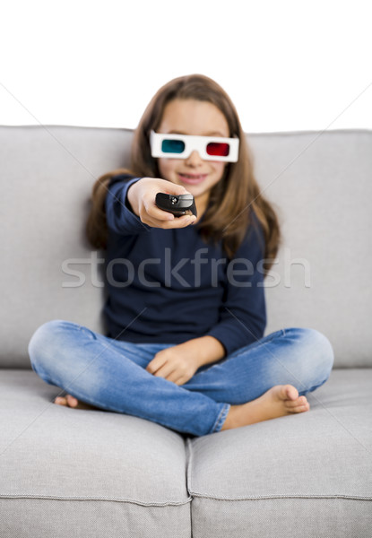 Girl holding a TV remote Stock photo © iko