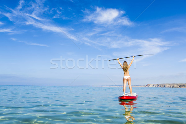 A beautiful and happy woman with arms up and learning paddle-sur Stock photo © iko