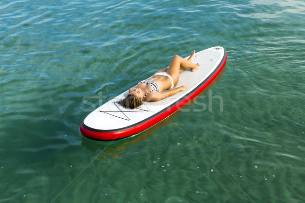 Woman relaxing over a paddle surfboard Stock photo © iko