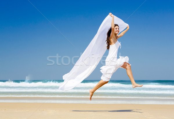 Jumping bianco tessuto bella donna esecuzione spiaggia Foto d'archivio © iko