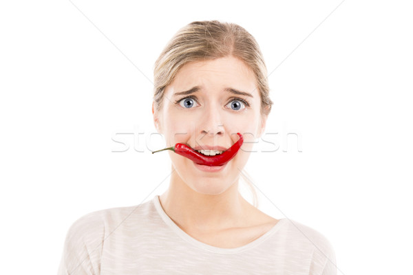 Woman with a silly face holding a red chilli pepper Stock photo © iko