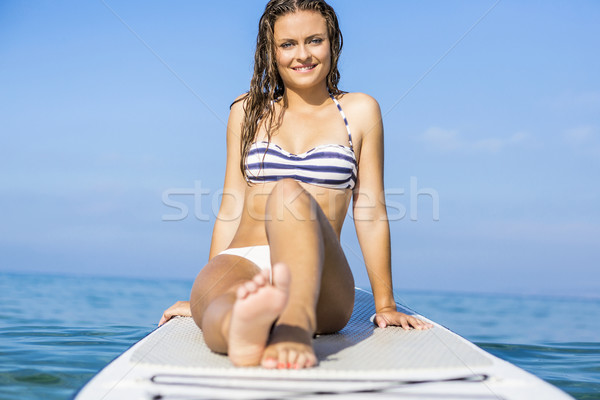 Woman sitting over a paddle surfboard Stock photo © iko