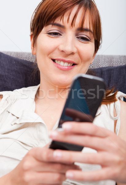 Küldés szöveges üzenet portré gyönyörű nő ülő kanapé Stock fotó © iko