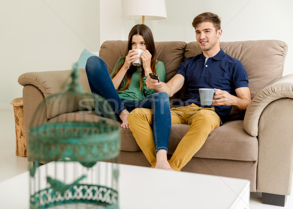 Néz tv iszik kávé fiatal pér kanapé Stock fotó © iko