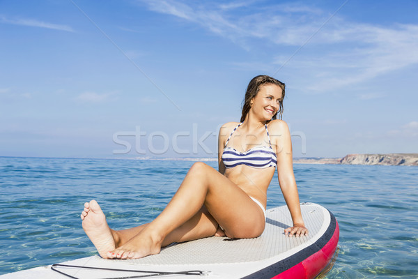 Woman sitting over a paddle surfboard Stock photo © iko