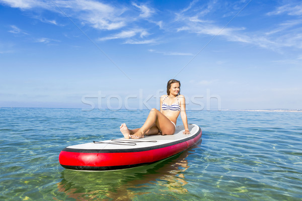 Woman sitting over a paddle surfboard Stock photo © iko