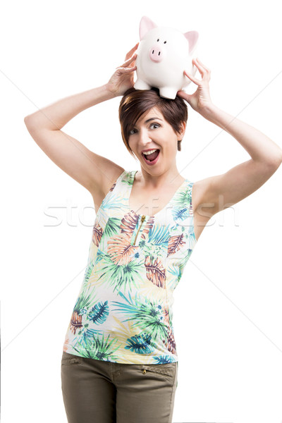 Stock photo: Woman holding a piggybank over her head