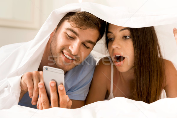 Using a cellphone under the sheets Stock photo © iko