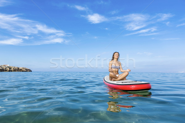 Woman relaxing over a paddle surfboard Stock photo © iko