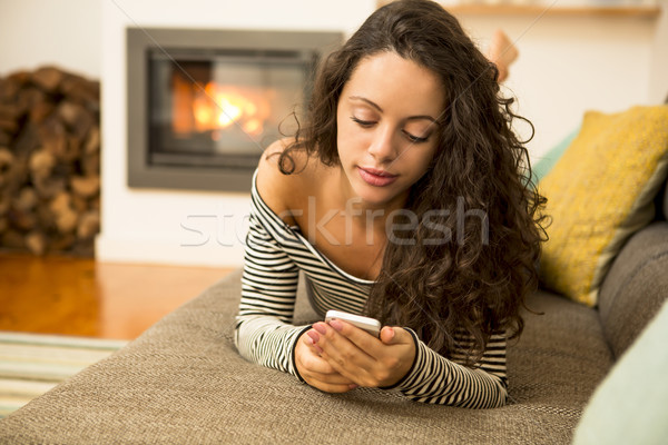 Nő mobiltelefon otthon gyönyörű nő melegség kandalló Stock fotó © iko