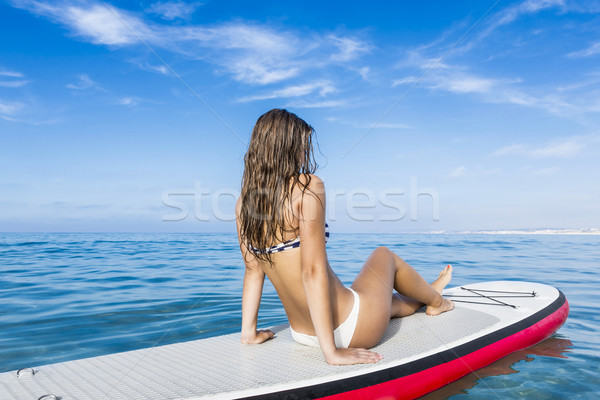 Woman sitting over a paddle surfboard Stock photo © iko