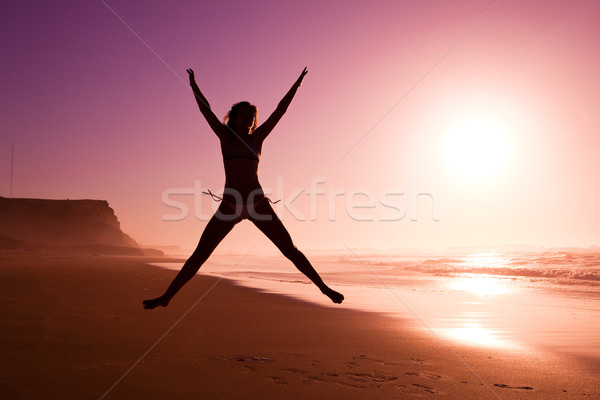 Jumping spiaggia foto femminile silhouette giovane ragazza Foto d'archivio © iko