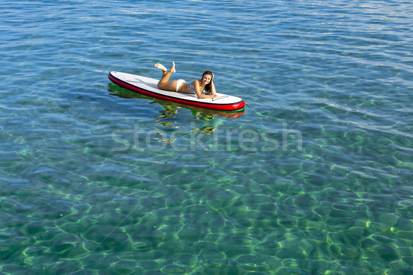 Woman relaxing over a paddle surfboard Stock photo © iko