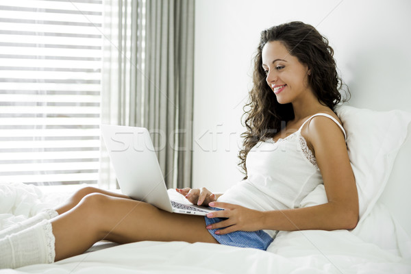 Lucru confort acasă femeie frumoasa laptop pat Imagine de stoc © iko