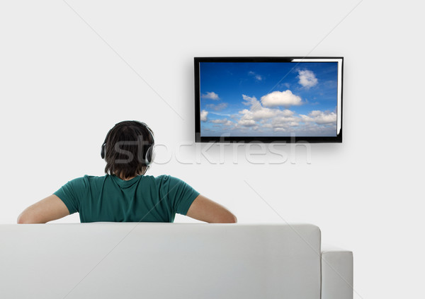 Regarder tv vue arrière jeune homme assis canapé [[stock_photo]] © iko