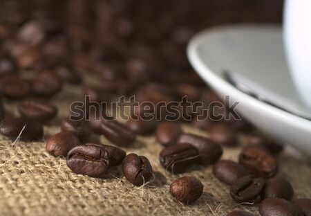 Foto d'archivio: Chicco · di · caffè · chicchi · di · caffè · tessuto · piattino · tazza · di · caffè · lato