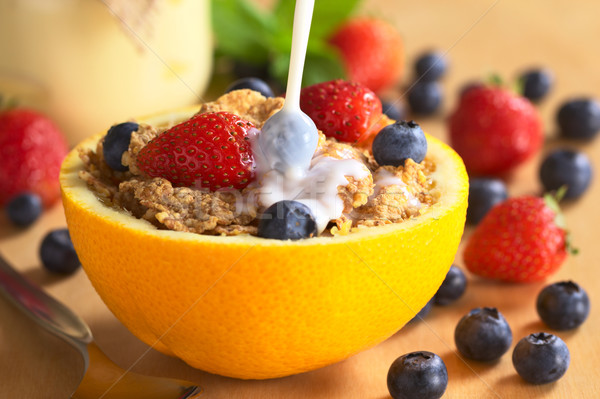 Pouring Milk Over Wholewheat Cereal with Fresh Fruits Stock photo © ildi