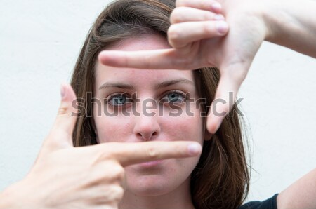 Young woman is focused view in the viewfinder gestures  Stock photo © ilolab