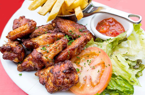 Chicken wings with sauce and golden French fries Stock photo © ilolab