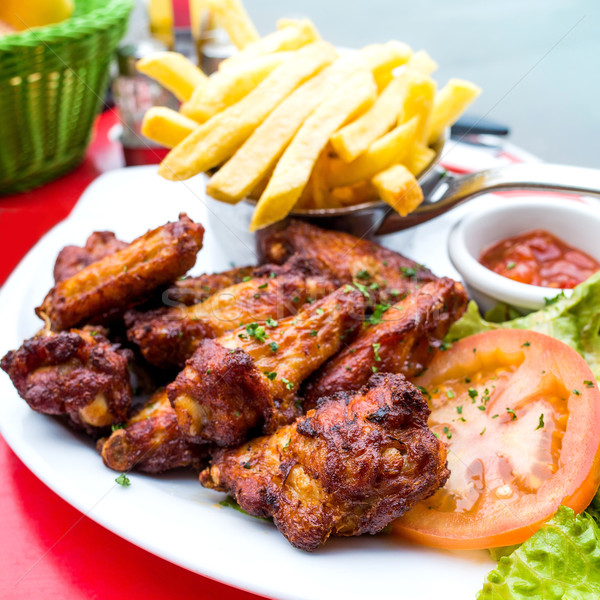 Chicken wings with sauce and golden French fries Stock photo © ilolab