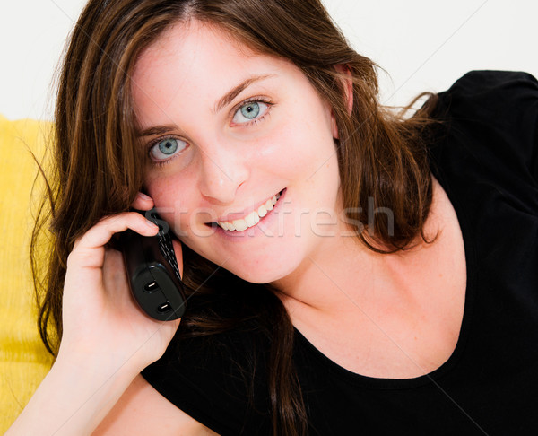 Beautiful happy woman on a white sofa making a phone call  Stock photo © ilolab