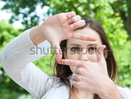 Young woman is focused view in the viewfinder gestures  Stock photo © ilolab
