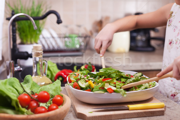 Stock photo: Little girl hands mixing the chopped vegetables into a salad, sh