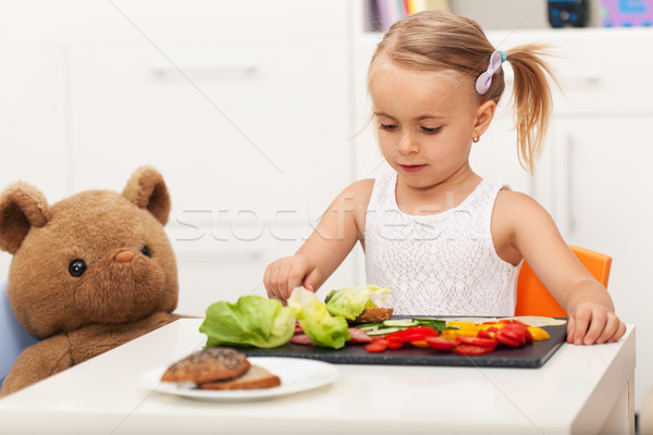 Little preschool girl having a healthy snack with her toy bear Stock photo © ilona75