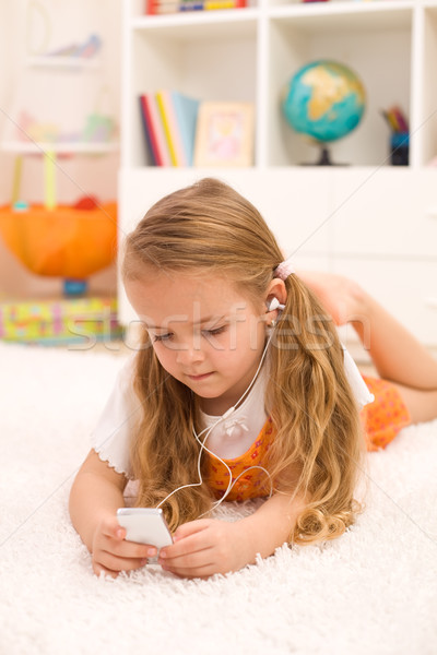 [[stock_photo]]: Petite · fille · écouter · de · la · musique · étage · chambre · musique