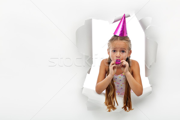 Surprise - little girl with party horn popping out from a torn p Stock photo © ilona75