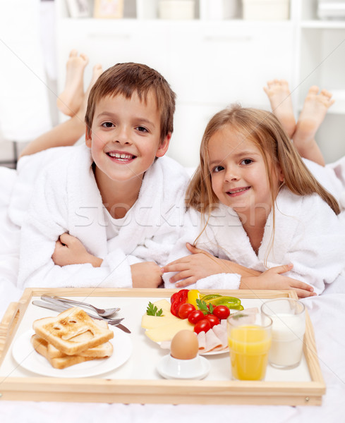 Happy kids having breakfast in bed Stock photo © ilona75
