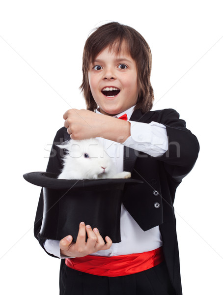 Young magician boy taking a rabbit out of his hat Stock photo © ilona75